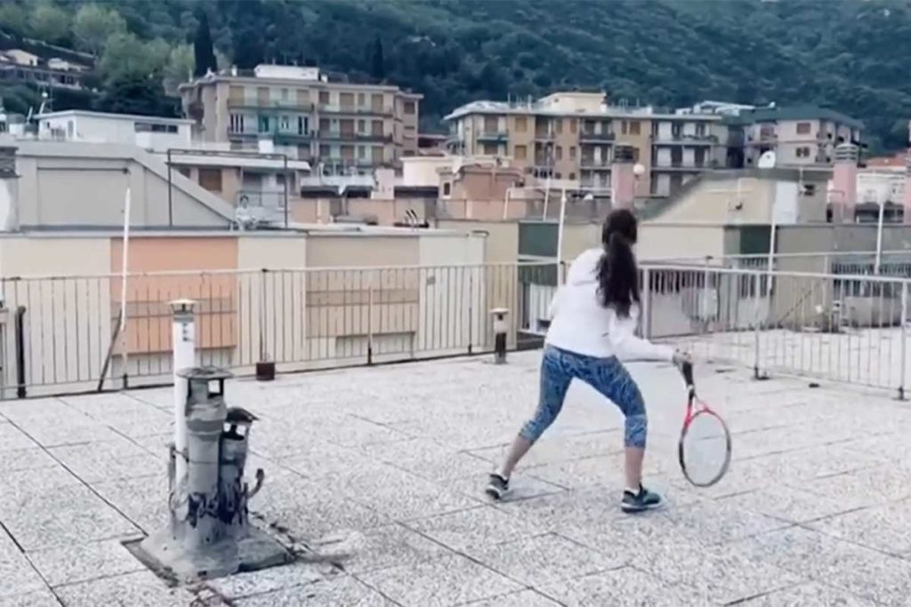 Two women play rooftop tennis in Liguria, Italy