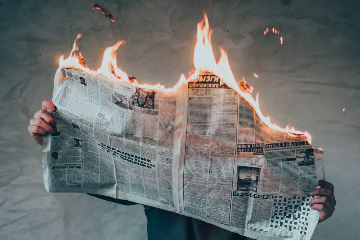 person reading a newspaper on fire