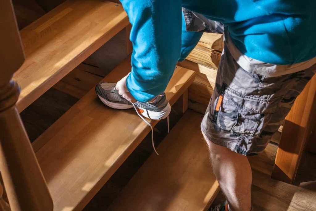A man tying shoes on stairs