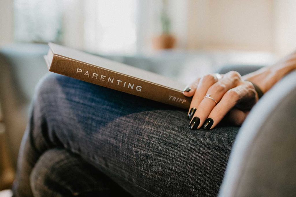 a mother reading a book on parenting