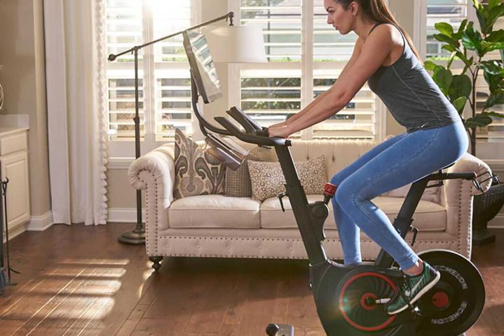 a woman cycling on an echelon fitness bike inside her living room